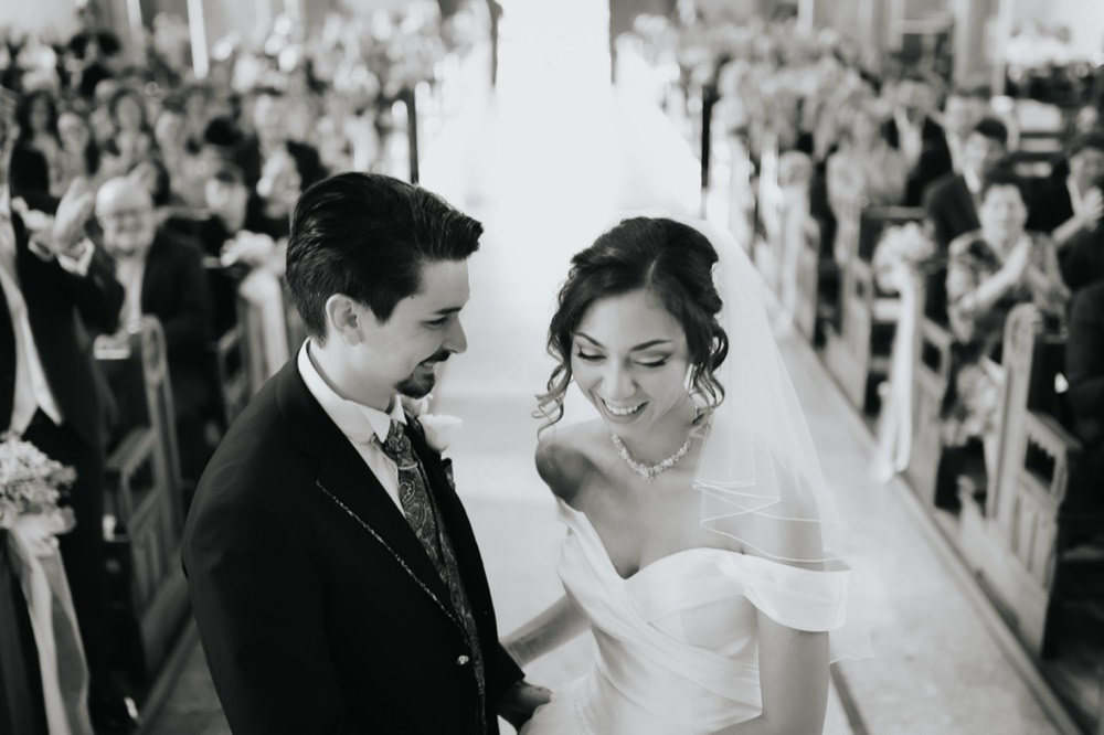 The couple looking at each other at the altar, black and white