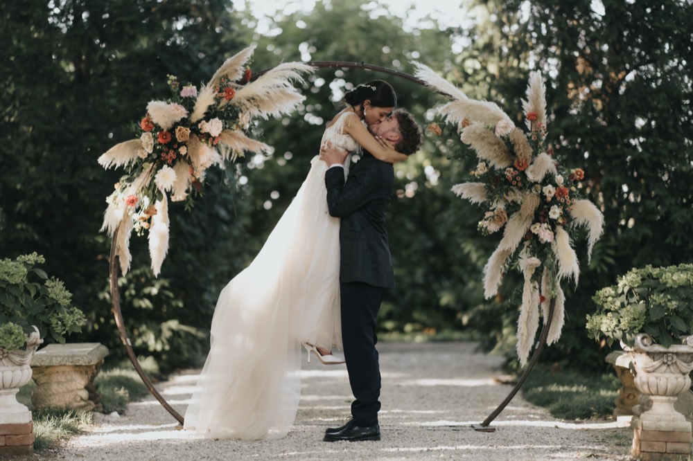 A kiss under the floral arch