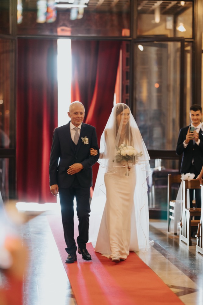 The father walking the bride down the red carpet