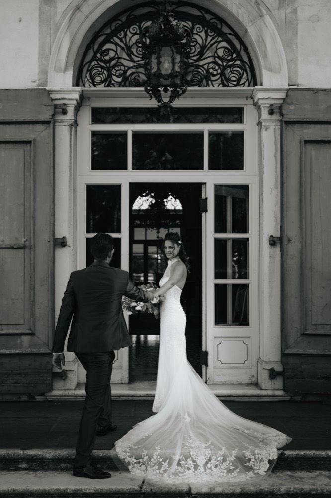 La sposa con lo strascico davanti a una porta, in bianco e nero