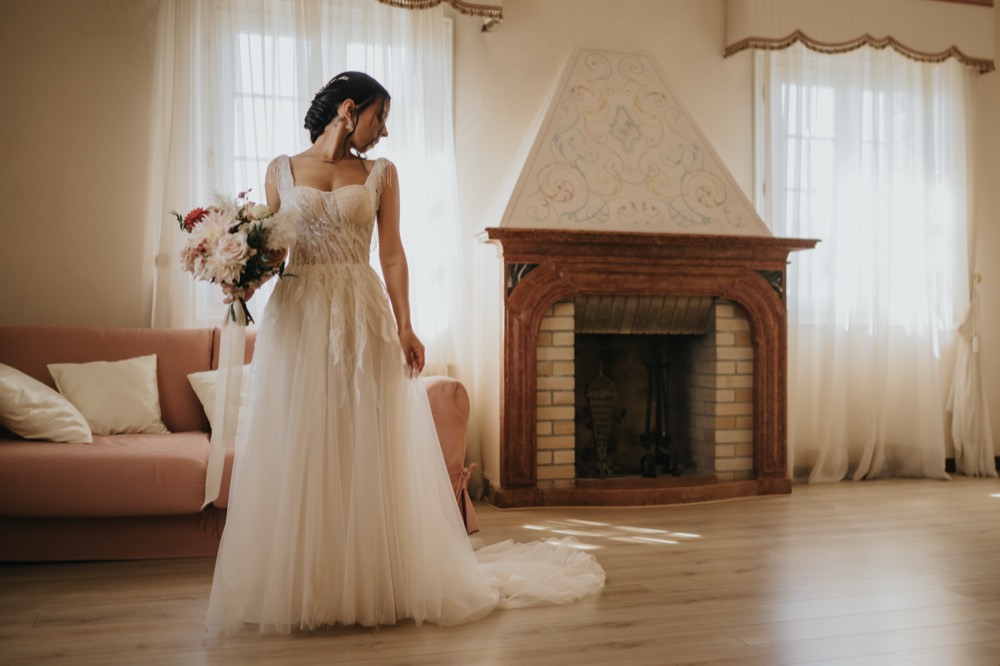 The bride standing in the room with her bouquet