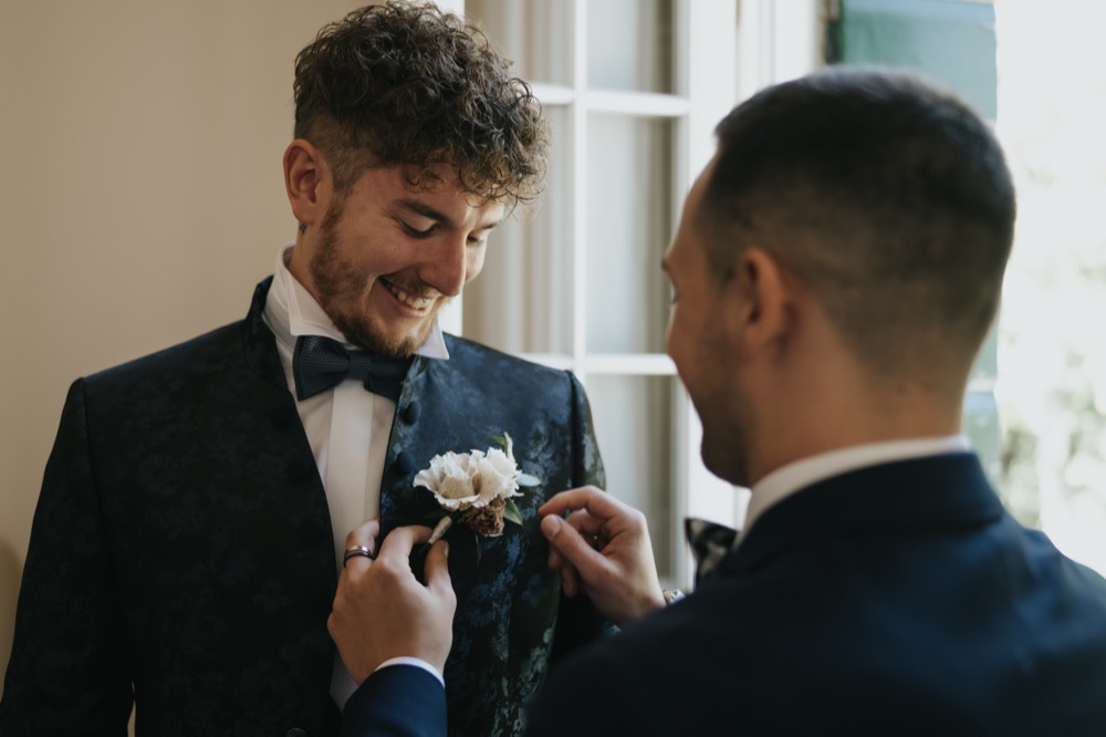 The best man fixing the groom’s buttonhole