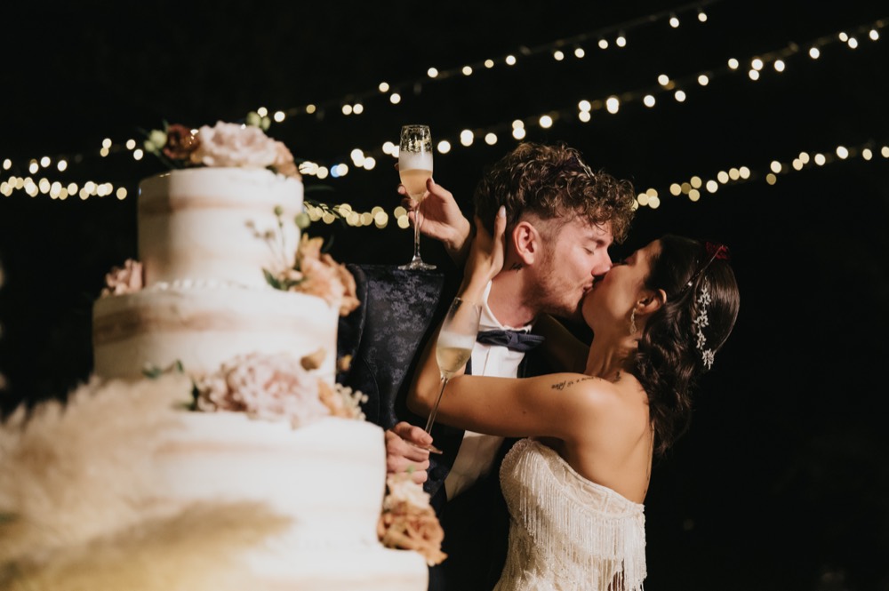 A kiss beside the wedding cake