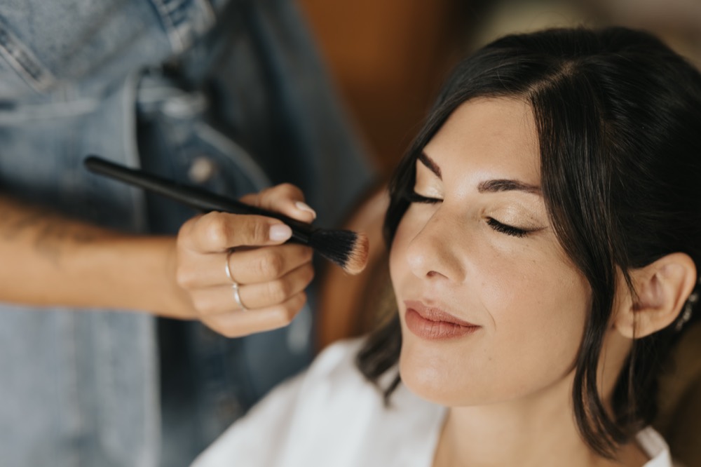 The bride with her eyes closed during make-up