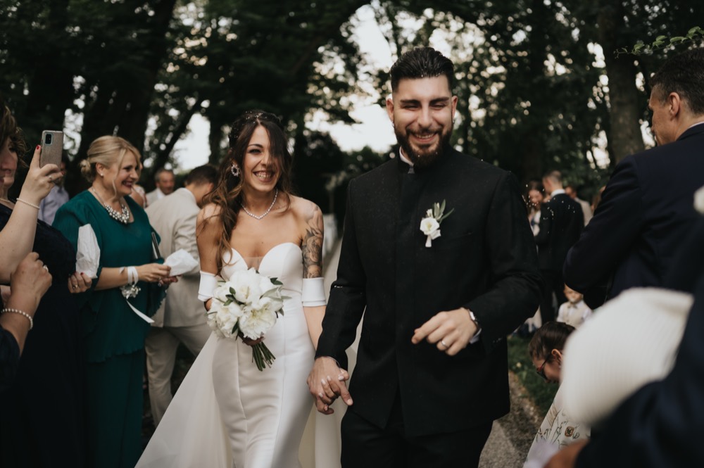 Sposi che escono sorridenti tra gli invitati