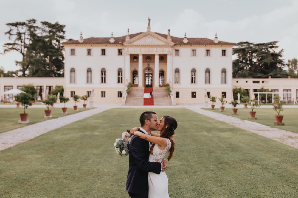 The couple on the lawn in front of a Palladian villa